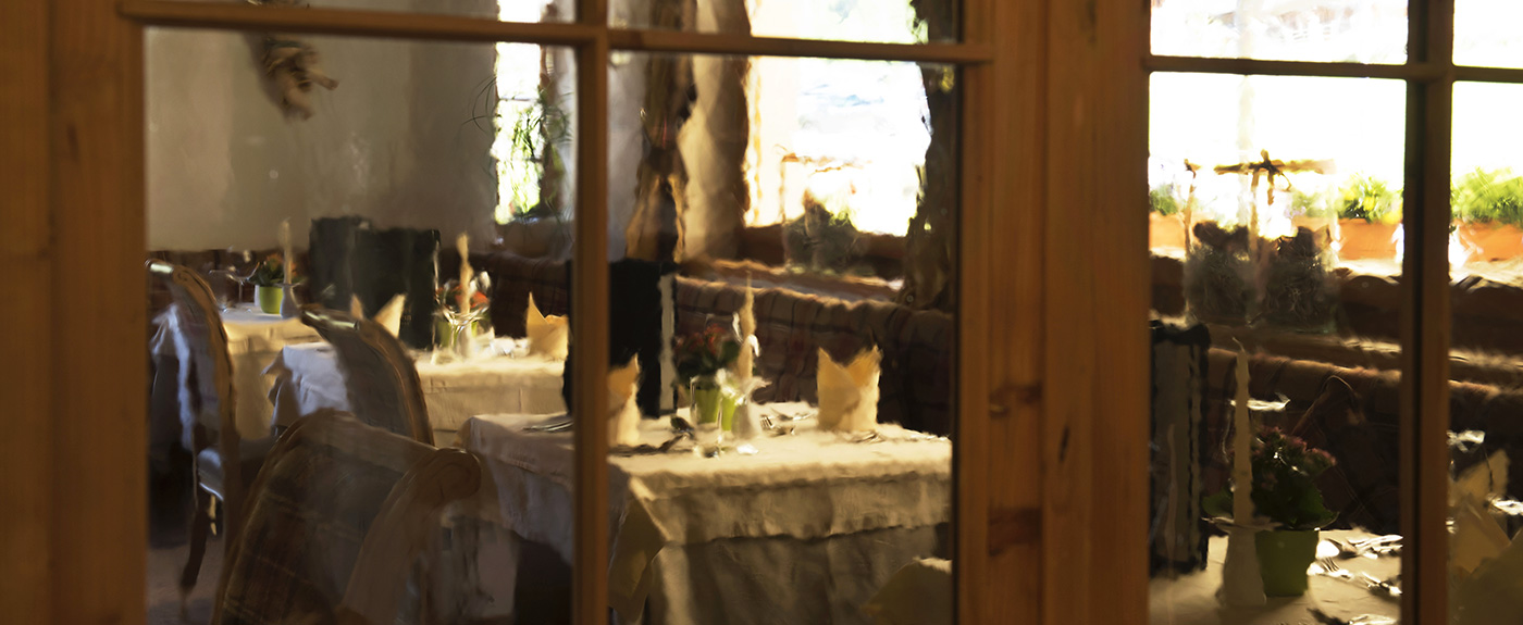 Blick durch die Fensterscheiben auf die gedeckten Tische im Restaurant