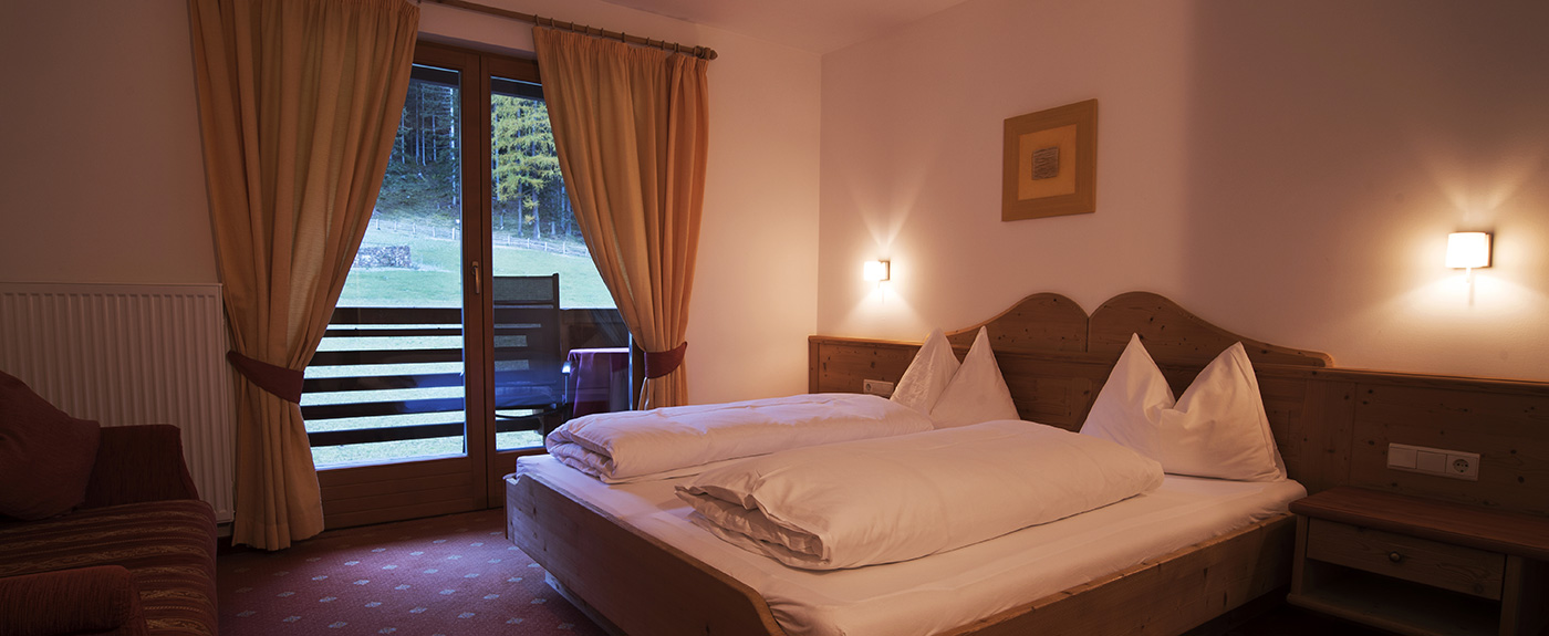 Double bed with view through the windows on the balcony